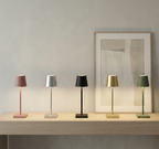 Five table lamps on a wooden surface with a abstract painting in the background